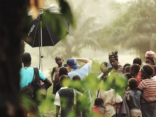John Keatley photographing a young boy in the Dark Forrest village in Liberia.