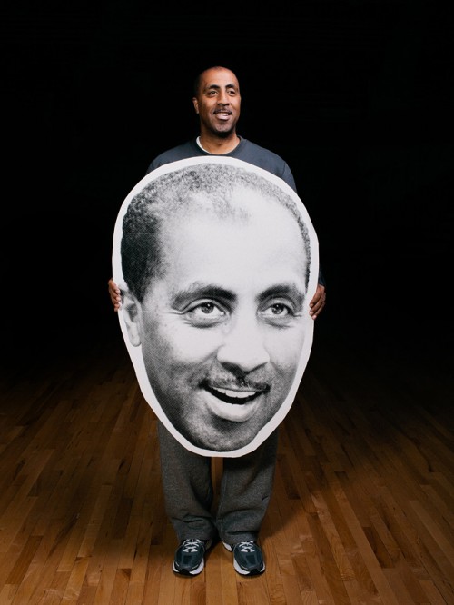 UW men's basketball coach Lorenzo Romar holding a giant picture of his face.  Photo by John Keatley.